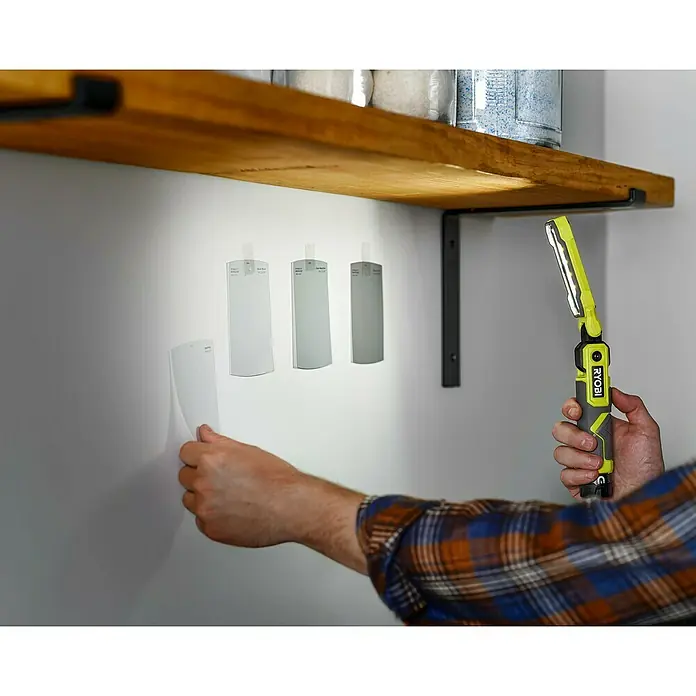 Ryobi 4V USB Akku-Stableuchte RLI4-0 - 4 V, Ohne Akku - Das Bild zeigt Farbmuster an einer Wand, die mit einer RYOBI Arbeitsleuchte beleuchtet werden, um die Farbwirkung zu prüfen.