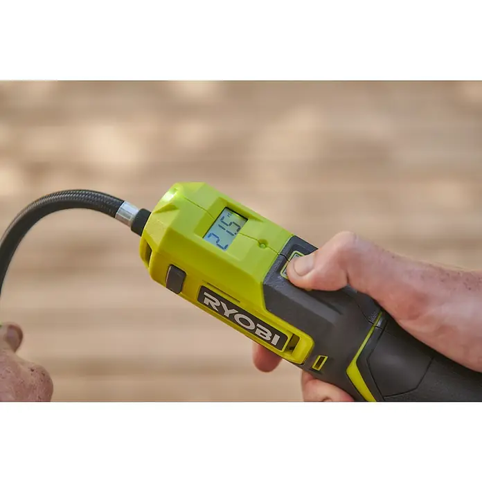 Ryobi 4V USB Akku-Kompressor Mini RI4-0 - 4 V, Ohne Akku, 6,9 bar - Nahaufnahme einer RYOBI-Luftpumpe in der Hand, die den Reifendruck anzeigt und bereit für den Gebrauch ist.