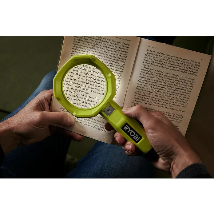 Ryobi 4V USB Akku-Lupenleuchte RML4-120G - 4 V, 1 Akku, 2 Ah - Nahaufnahme einer RYOBI-Lupe, die zum Lesen eines Buches verwendet wird. Ideal für Detailarbeiten und Sehschwäche.