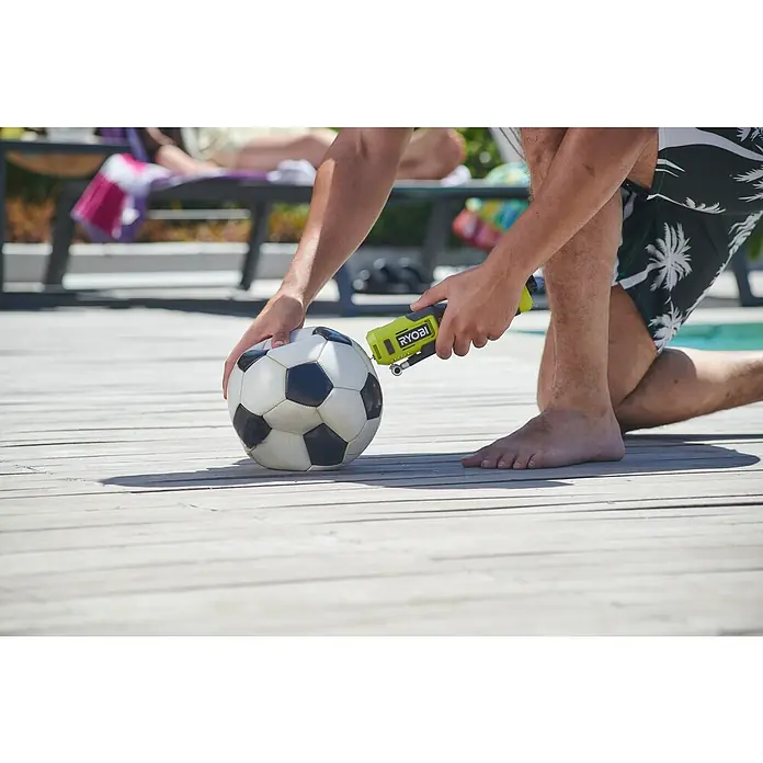 Ryobi 4V USB Akku-Kompressor Mini RI4-0 - 4 V, Ohne Akku, 6,9 bar - Nahaufnahme einer Person, die einen Fußball mit einer gelben und schwarzen RYOBI Luftpumpe auf einem Holzdeck aufpumpt.