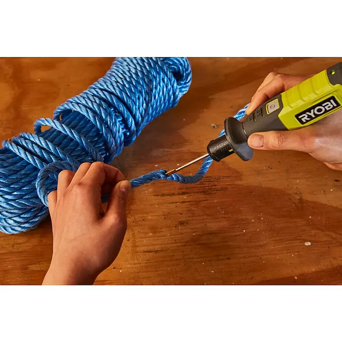 Ryobi 4V USB Akku-Heißdrahtschneider RHC4 - 4 V, 1 Akku, 2 Ah - Ein hellblaues Seil wird mit einem RYOBI-Werkzeug auf einem Holztisch bearbeitet, wobei die Handhabung und Präzision des Werkzeugs im Fokus stehen.