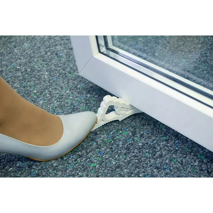 Schellenberg Tür- & Fensterstopper - Weiß - Ein weißer Keil verkeilt eine weiße Tür, während ein beigefarbener High Heel daneben steht.