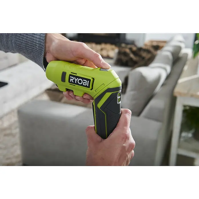 Ryobi 4V USB Akku-Knickschrauber RSDP4-120G - 4 V, 1 Akku, 2 Ah, 5 Nm - Eine Nahaufnahme eines Ryobi-Akkuschraubers in den Händen einer Person, der für Heimwerkerprojekte oder Reparaturen verwendet wird.