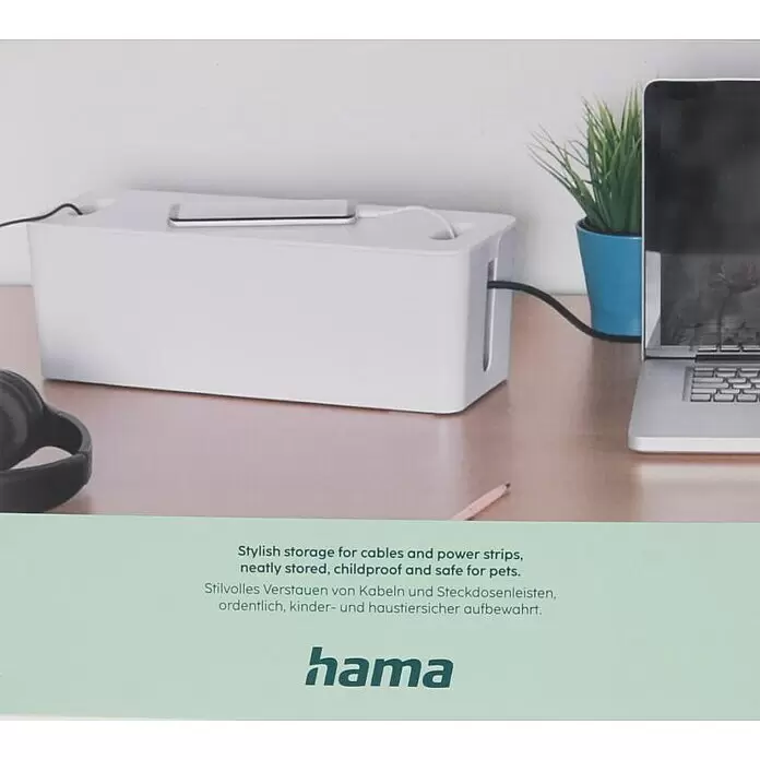 Hama Kabelbox Maxi mit Kabelführung im Deckel - Weiß - Weiße Kabelmanagement-Box auf einem Schreibtisch, die Kabel und Steckdosenleisten sicher organisiert.
