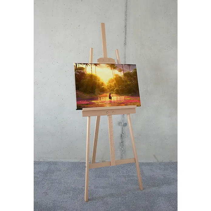 Komar Leinwandbild - Encanto - Madrigal Miracle, B x H: 60 x 40 cm - Gemaltes Kunstwerk auf einer Staffelei, das eine tropische Landschaft mit Sonnenuntergang und einer Person im Wasser zeigt.