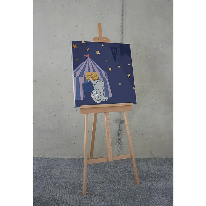Komar Dumbo Leinwandbild - Starry Night with Dumbo, B x H: 60 x 60 cm - Dumbo-Leinwandbild auf einer Staffelei. Das Bild zeigt Dumbo vor einem Zirkuszelt unter einem Sternenhimmel, ideal für Kinderzimmer.