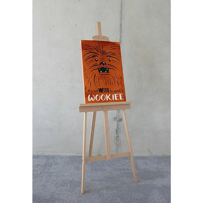 Komar Star Wars Leinwandbild - Star Wars Don´t Upset Wookiee, B x H: 40 x 60 cm - Ein orangefarbenes, rechteckiges Gemälde von Chewbacca auf einer Holzstaffelei mit dem Zitat "Es ist nicht klug, einen Wookiee zu verärgern".