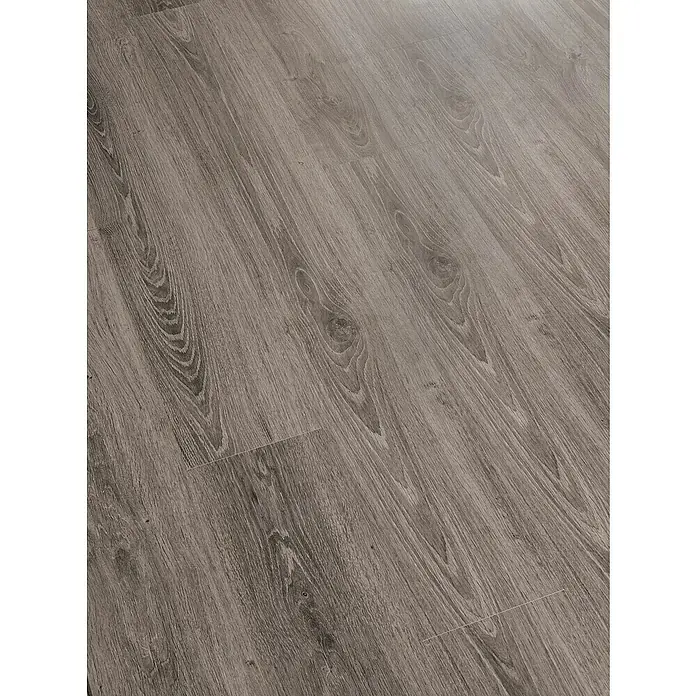 LOGOCLIC Laminado Roble Hiedra - 1.380 x 193 x 7 mm, AC5 - Primer plano de suelo laminado con un patrón de madera. El pavimento añade un ambiente cálido y acogedor a cualquier habitación.