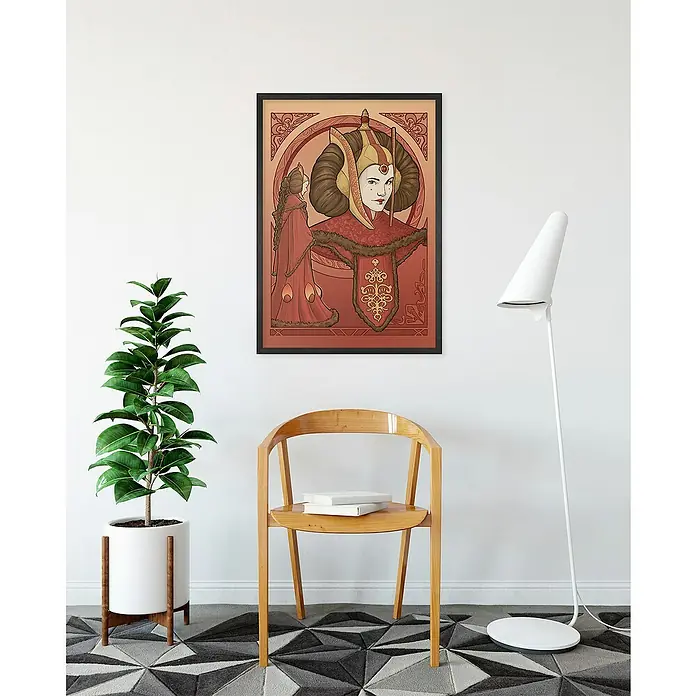 Komar Star Wars Poster - Star Wars - Queen Padmé Amidala, B x H: 30 x 40 cm - Dieses Bild zeigt ein gerahmtes Queen Amidala-Poster im Art Nouveau-Stil, das an einer weißen Wand über einem hellen Holzstuhl hängt.