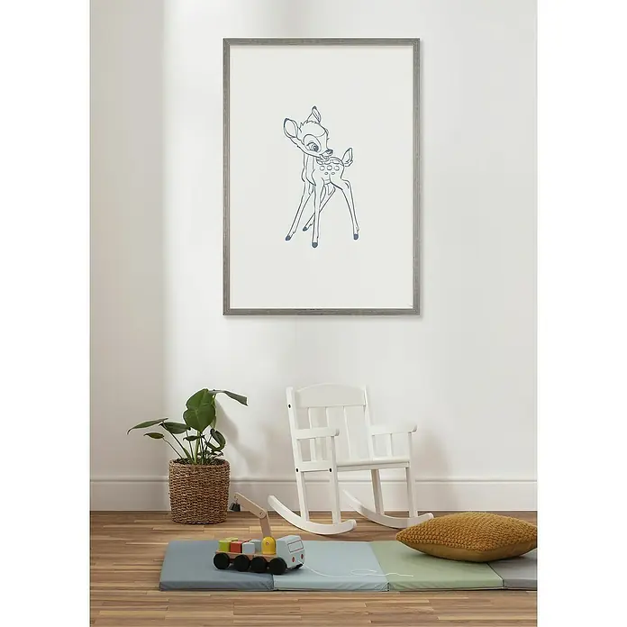 Komar Bambi Poster - Little Bambini, B x H: 40 x 50 cm - Ein Kinderzimmer mit einem gerahmten Bild von Bambi an der Wand, einem Schaukelstuhl und Spielzeug auf dem Boden.