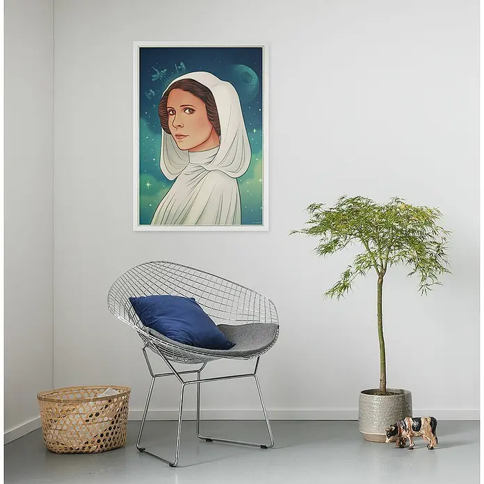 Komar Star Wars Poster - Star Wars - Princess of Alderaan, B x H: 50 x 70 cm - Ein gerahmtes Poster von Prinzessin Leia hängt an einer Wand, unter dem ein Design-Stuhl, ein Korb und eine Zimmerpflanze zu sehen sind.
