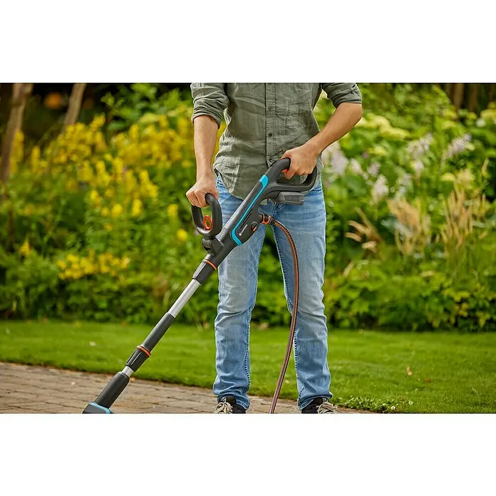 Gardena Power for All 18V Akku-Reinigungsbürste AquaBrush Patio 03/18V - 1 Akku - Eine Person benutzt einen Gardena Akku-Fugenreiniger, um Unkraut zu entfernen. Der Fugenreiniger ist ein hochwertiges Gartengerät für eine effiziente Reinigung.