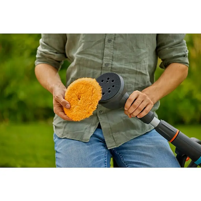 Gardena Power for All 18V Akku-Reinigungsbürste AquaBrush Compact 02/18V - Ohne Akku - Der Mann hält einen GARDENA Akku-Fugenkratzer mit Bürstenaufsatz, ideal für die effektive und kabellose Unkrautentfernung in Ihrem Garten.