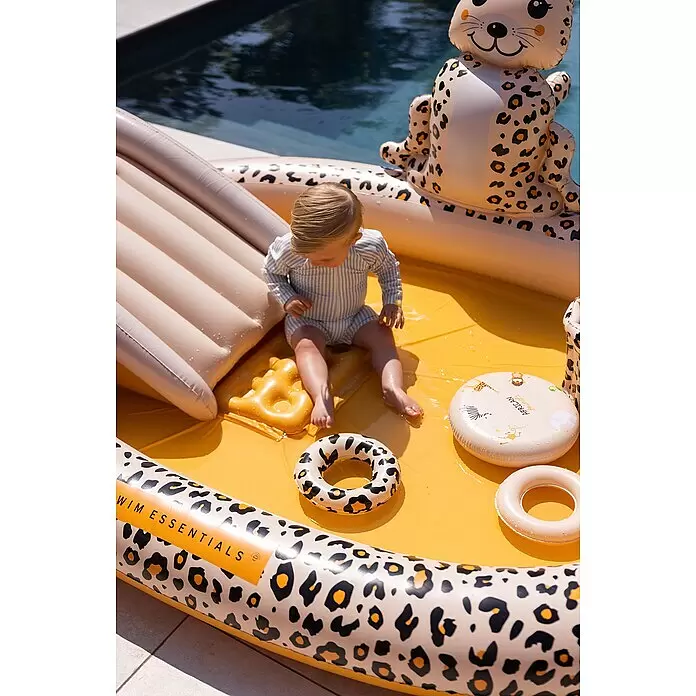 Swim Essentials Piscina hinchable - 203 x 173 x 89 cm, Leopardo - Bebé en una piscina hinchable con estampado de leopardo y tobogán, llena de agua, junto a una piscina grande.