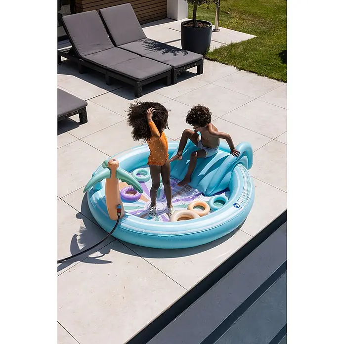 Swim Essentials Planschbecken203 x 173 x 89 cm - Zwei Kinder spielen in einem hellblauen Planschbecken mit Wasserrutsche und Sprinkleranlage im Garten.