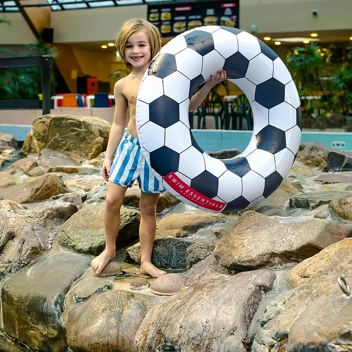Swim Essentials Schwimmring - Durchmesser: 90 cm, Fussball - Junge mit Schwimmring im Fußball-Design am Beckenrand. Perfekt für kleine Wasserratten, die Spaß am Schwimmen haben.