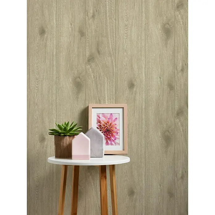 A.S. Création Best Of Wood&Stone 2 Vliestapete - Braun, Holzoptik, 10,05 x 0,53 m - Ein stilvolles Arrangement mit einer Zimmerpflanze, Deko-Häusern und einem Bilderrahmen auf einem kleinen Tisch vor einer Holzpaneelwand.