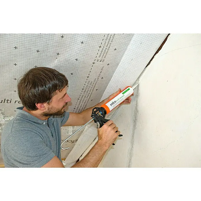 Steico Dampfbremsfolie multi renova - 50 x 1,5 m, 75 m² - Ein Mann dichtet mit STEICO multi connect eine Wand ab. Die Dichtmasse sorgt für eine zuverlässige Abdichtung im Innenbereich.