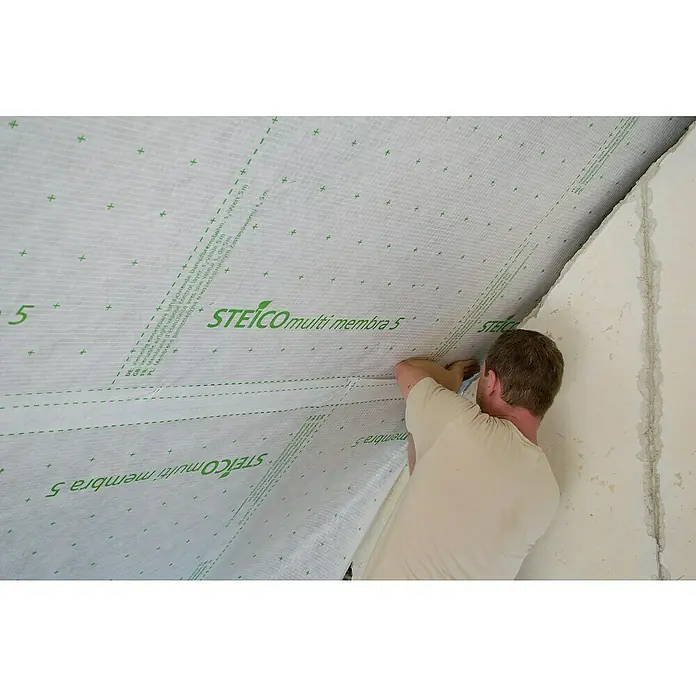 Steico Dampfbremsfolie multi membra 5 - 50 x 1,5 m, 75 m² - Ein Handwerker befestigt eine STEICO multi membra 5 Dampfbremsbahn an einer Dachschräge, um für ein gesundes Raumklima zu sorgen.