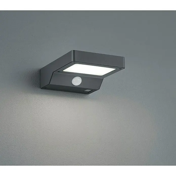 Reality Leuchten Solar-Außenwandleuchte Fomosa - 5 W, L x B x H: 16,5 x 12,5 x 4,5 cm, IP44, 340 lm - Bild einer anthrazitfarbenen LED-Wandleuchte mit Bewegungsmelder an einer grauen Wand, die ein helles Licht ausstrahlt.