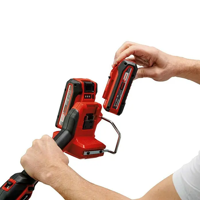 Einhell Professional PXC 18V Recortabordes de batería GP-CT36/35Li - 36 V, Iones de litio, Sin batería, Ancho de corte hilo: 35 cm - El serrucho de altura a batería Einhell funciona con una batería Power X-Change. Se está insertando una batería.