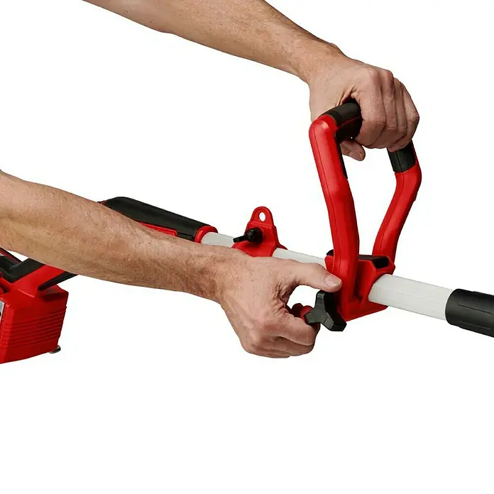 Einhell PXC 18V Recortabordes de batería GP-CT36/35Li + Batería y cargador PXC-Starter kit - 36 V, Iones de litio, 2 baterías, Ancho de corte hilo: 35 cm - Primer plano de un cortacésped con mango rojo, sujetado por dos manos. El cortacésped es blanco y rojo y tiene una batería.