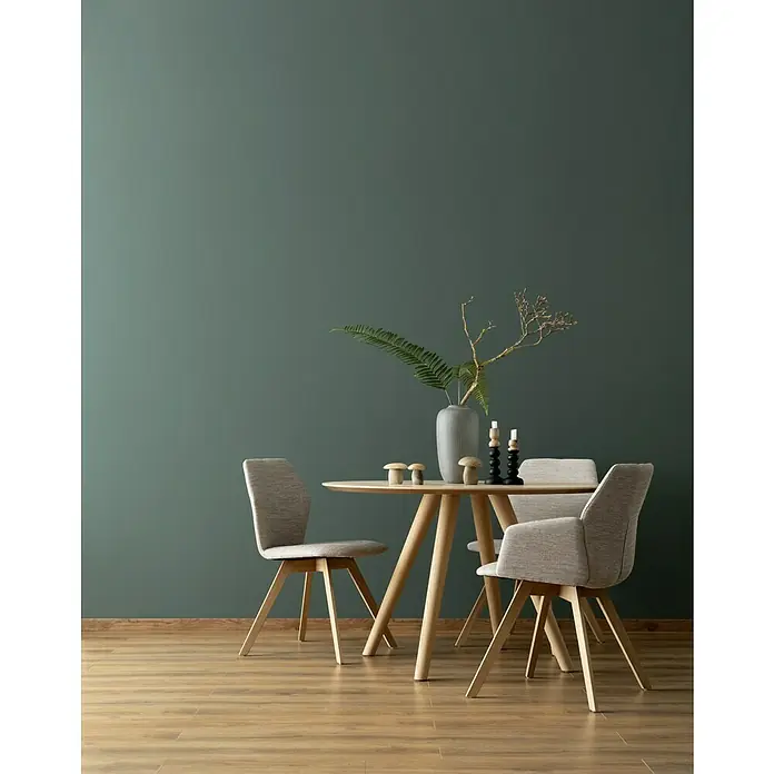 SCHÖNER WOHNEN-Farbe Wandfarbe DesignfarbeBesinnliches Waldgrün, Matt, 1 l, Konservierungsmittelfrei - Ein Esstisch mit Stühlen, geschmückt mit Kerzen und einem Farn in einer Vase, schafft eine gemütliche Atmosphäre.