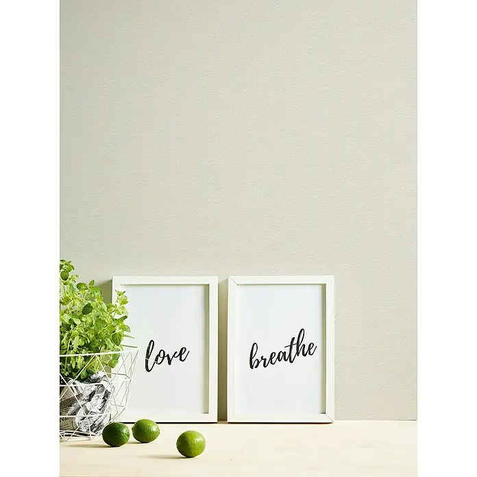 A.S. Création Casual Living Vliestapete - Creme/Weiß, Uni, 10,05 x 0,53 m - Elegante Wanddekoration mit zwei gerahmten Bildern, die die Worte "Liebe" und "Atmen" darstellen, umgeben von einer Pflanze und Limetten.