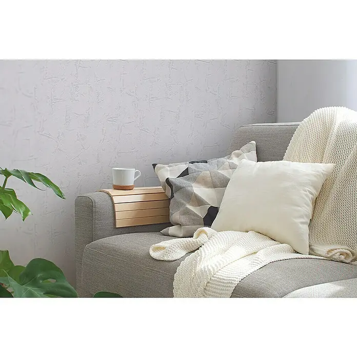 A.S. Création Casual Living Vliestapete Strukturtapete - Weiß, Uni, 10,05 x 0,53 m - Nahaufnahme eines stilvollen Sofas mit Kissen und einer Tasse auf einem Holztablett, perfekt für gemütliche Momente.