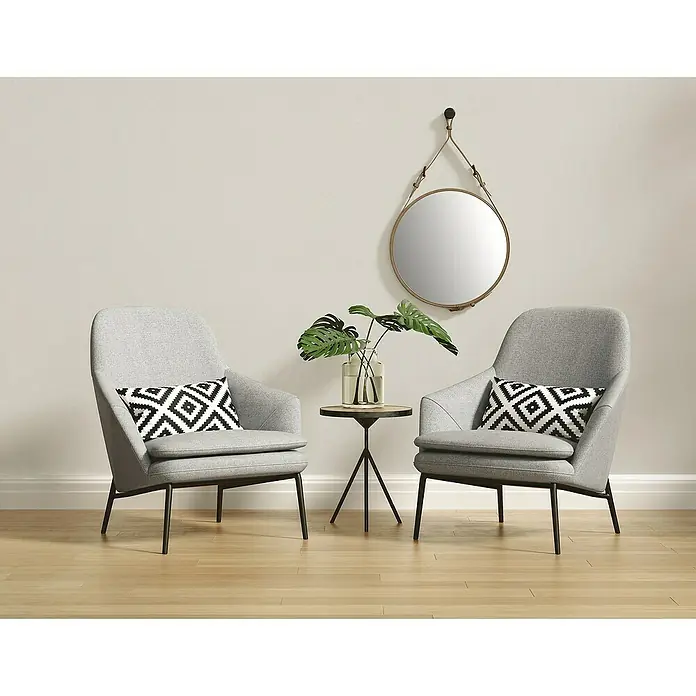 A.S. Création Casual Living Vliestapete - Cremiges Weiß, Uni, 10,05 x 0,53 m - Zwei graue Sessel mit geometrischen Kissen und einem runden Spiegel an der Wand schaffen eine gemütliche Atmosphäre.