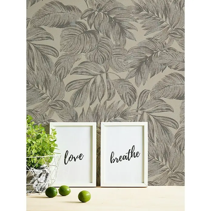 A.S. Création Casual Living Vliestapete - Braun/Grau/Beige, Floral, 10,05 x 0,53 m - Dekorative Szene mit weißen Rahmen, die mit inspirierenden Wörtern bedruckt sind, und einem grünen Kräutertopf vor einer botanischen Tapete.
