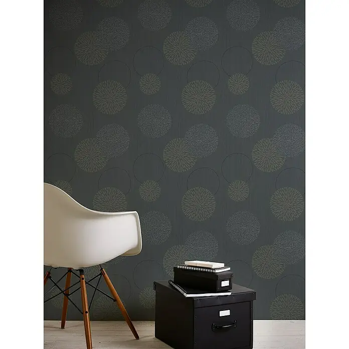 A.S. Création Casual Living Vliestapete Kreise - Anthrazit-Grau, Grafisch, 10,05 x 0,53 m - Einrichtungsaufnahme mit einer Aktenbox und einem stilvollen Stuhl vor einer eleganten Wand mit Muster.