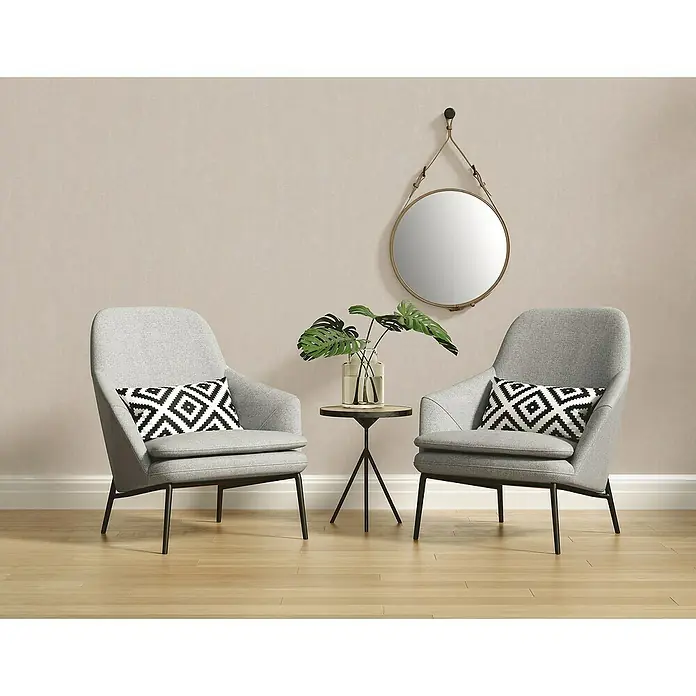 A.S. Création Casual Living Vliestapete - Harmonisches Beige, Uni, 10,05 x 0,53 m - Zwei graue Sessel mit einem kleinen Tisch und einer Wanddekoration schaffen eine gemütliche Atmosphäre im Raum.