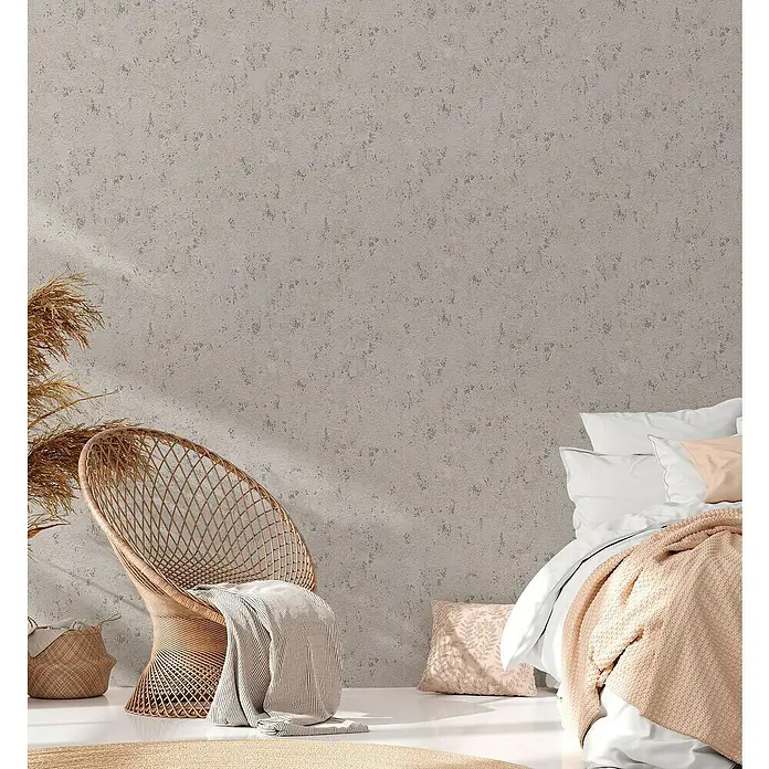 A.S. Création Casual Living Vliestapete Struktur - Grau/Beige/Silber, Uni, 10,05 x 0,53 m - Einladendes Schlafzimmer mit Rattansessel, weichen Textilien in Rosatönen und einer strukturierten Wand für eine gemütliche Atmosphäre.