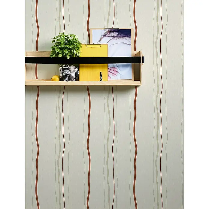 A.S. Création Casual Living Vliestapete - Creme/Rot/Beige, Streifen, 10,05 x 0,53 m - Nahaufnahme eines hellen Wandregals mit einem kleinen Pflanzgefäß, Zitrone, gelbem Notizblock und Bildern vor einer gestreiften Tapete.