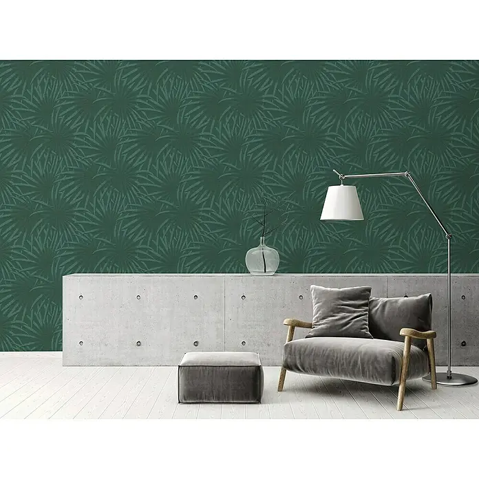 A.S. Création Casual Living Vliestapete Palmenblätter - Grün/Dunkelgrün, Floral, 10,05 x 0,53 m - Das Bild zeigt eine stilvolle Wand mit dunkelgrüner Blättertapete, die eine elegante und moderne Atmosphäre schafft.