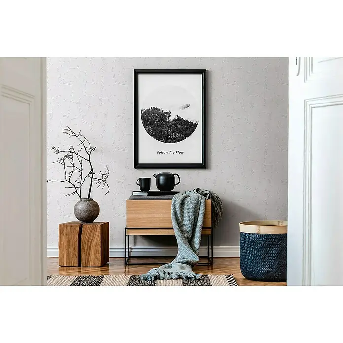 A.S. Création Casual Living Vliestapete Strukturtapete - Weiß, Uni, 10,05 x 0,53 m - Elegantes Interieur mit einem schwarzen Bilderrahmen mit dem Aufdruck "Follow The Flow" über einem Nachttisch mit Dekorationen.