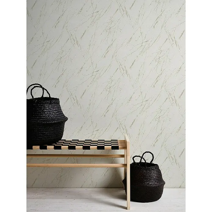 A.S. Création Casual Living Vliestapete Marmor - Weiß/Champagner/Metallic, Steinoptik, 10,05 x 0,53 m - Ein stilvolles Interieur mit einem hellen Holzregal, schwarzen Körben und einer gemusterten Wand, die eine moderne und minimalistische Atmosphäre schafft.