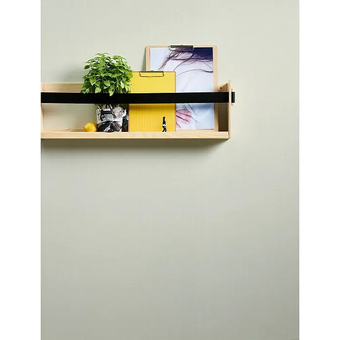 A.S. Création Casual Living Vliestapete Textiloptik - Weiß, Uni, 10,05 x 0,53 m - Wandregal mit Pflanze, Zitrone, gelben Ordnern und Foto. Das Regal ist aus hellem Holz und hat einen schwarzen Halter.