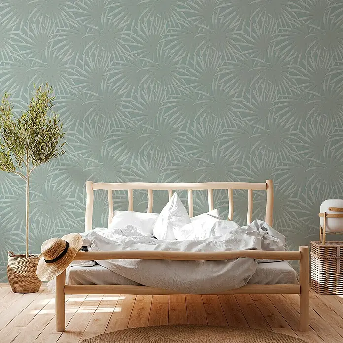 A.S. Création Casual Living Vliestapete Palmenblätter - Blau/Mint, Floral, 10,05 x 0,53 m - Elegantes Schlafzimmer mit einem hellen Holzrahmenbett, weißer Bettwäsche und einem kleinen Baum im Topf. Die Wand ist mit einem zarten Blattmuster verziert.