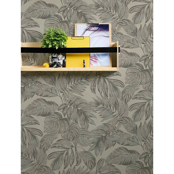 A.S. Création Casual Living Vliestapete - Braun/Grau/Beige, Floral, 10,05 x 0,53 m - Wandregal mit Deko-Elementen vor einem Hintergrund mit tropischen Blättern. Das Regal ist mit einer Pflanze, Bildern und einer Zitrone dekoriert.