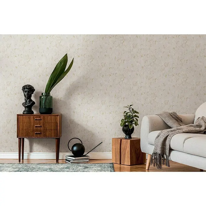 A.S. Création Casual Living Vliestapete Struktur - Grau/Gold/Metallic, Uni, 10,05 x 0,53 m - Einrichtungsidee mit einem stilvollen Holzschrank, einer grauen Couch und dekorativen Elementen wie einer Büste und Pflanzen für ein gemütliches Ambiente.