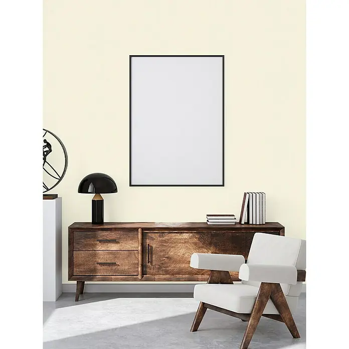 A.S. Création Casual Living Vliestapete - Beigeweiß, Uni, 10,05 x 0,53 m - Ein elegantes Interieur mit einem modernen Holzschrank, einem stilvollen Stuhl und einem leeren Rahmen, ideal für Kunstwerke.
