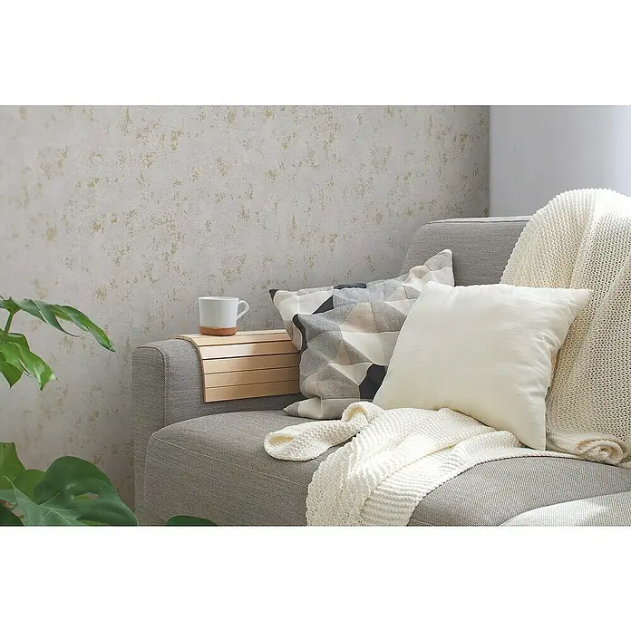 A.S. Création Casual Living Vliestapete Struktur - Grau/Gold/Metallic, Uni, 10,05 x 0,53 m - Gemütliches Sofa mit Kissen und Überwurf in neutralen Farben, dazu ein praktisches Tablett am Arm für die Kaffeetasse. Stilvolle Einrichtung für Zuhause.