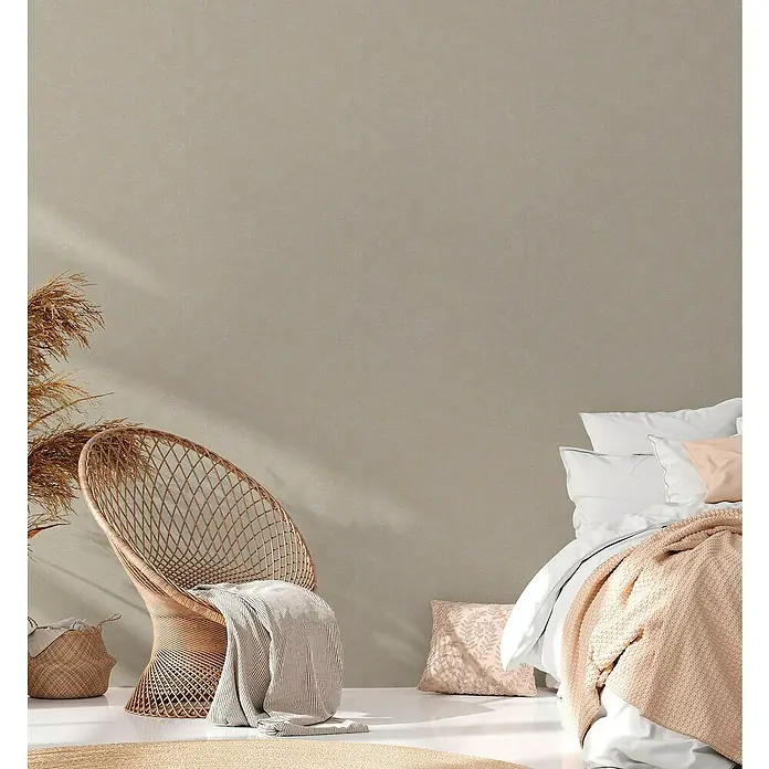 A.S. Création Casual Living Vliestapete - Grau/Beige, Uni, 10,05 x 0,53 m - Elegantes Interieur mit einem Korbstuhl, weichen Kissen und einer hellen Decke. Das Design strahlt Wärme und Komfort in einem stilvollen Ambiente aus.