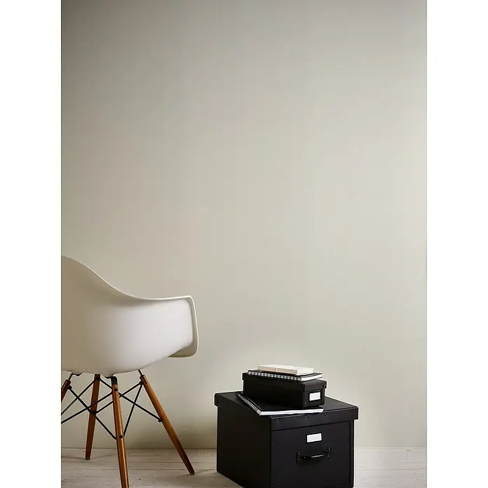 A.S. Création Casual Living Vliestapete Textiloptik - Weiß, Uni, 10,05 x 0,53 m - Minimalistisches Interieur mit einem weißen Stuhl und schwarzen Aufbewahrungsboxen, die Funktionalität und Stil verbinden.