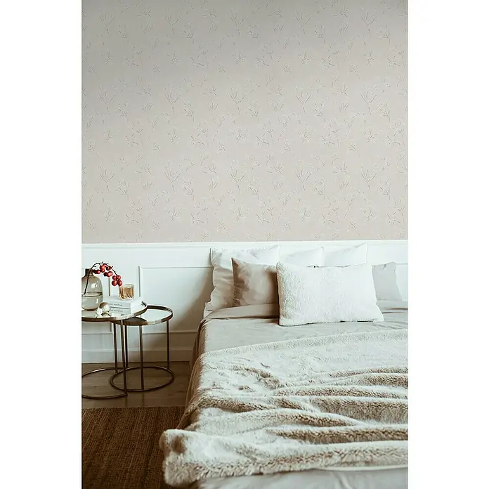 A.S. Création Casual Living Vliestapete Blümchen - Grau/Weiß, Floral, 10,05 x 0,53 m - Schlafzimmer-Szene mit einem gemütlichen Bett, stilvoller Dekoration und einer Wand mit einem dezenten, floralen Muster, die eine entspannende Atmosphäre schafft.