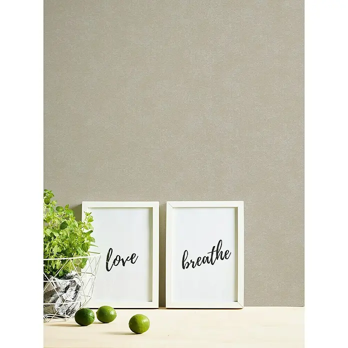 A.S. Création Casual Living Vliestapete - Grau/Beige, Uni, 10,05 x 0,53 m - Zwei gerahmte Kunstdrucke mit den Worten "Love" und "Breathe", neben einem Korb mit Grünpflanzen und Limetten auf einem Tisch.