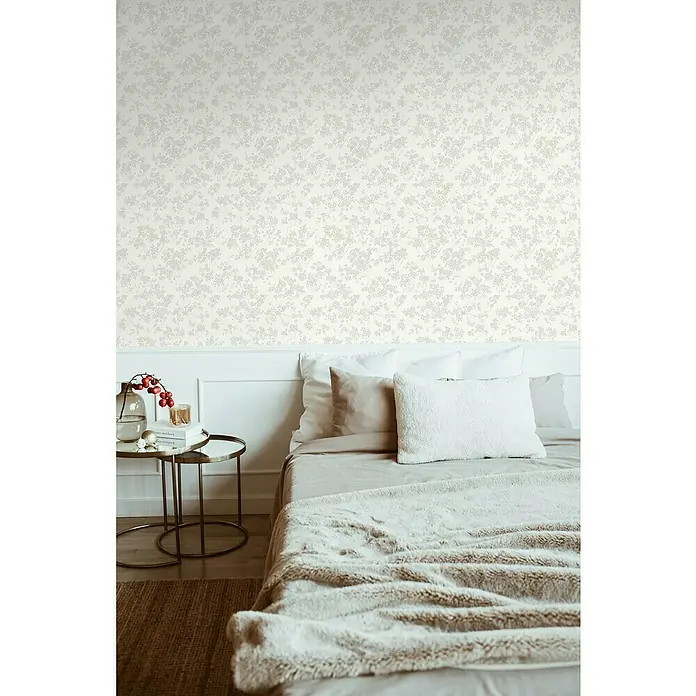 A.S. Création Casual Living Vliestapete Blümchen - Weiß/Grün/Grau, Floral, 10,05 x 0,53 m - Schlafzimmer mit Bett, Nachttisch und dekorativer Tapete.