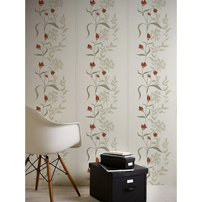 A.S. Création Casual Living Vliestapete - Creme/Rot/Beige, Floral, 10,05 x 0,53 m - Dekoratives Foto mit einem stilvollen Stuhl und einer eleganten Aufbewahrungsbox, die vor einer Wand mit floralem Muster platziert sind.